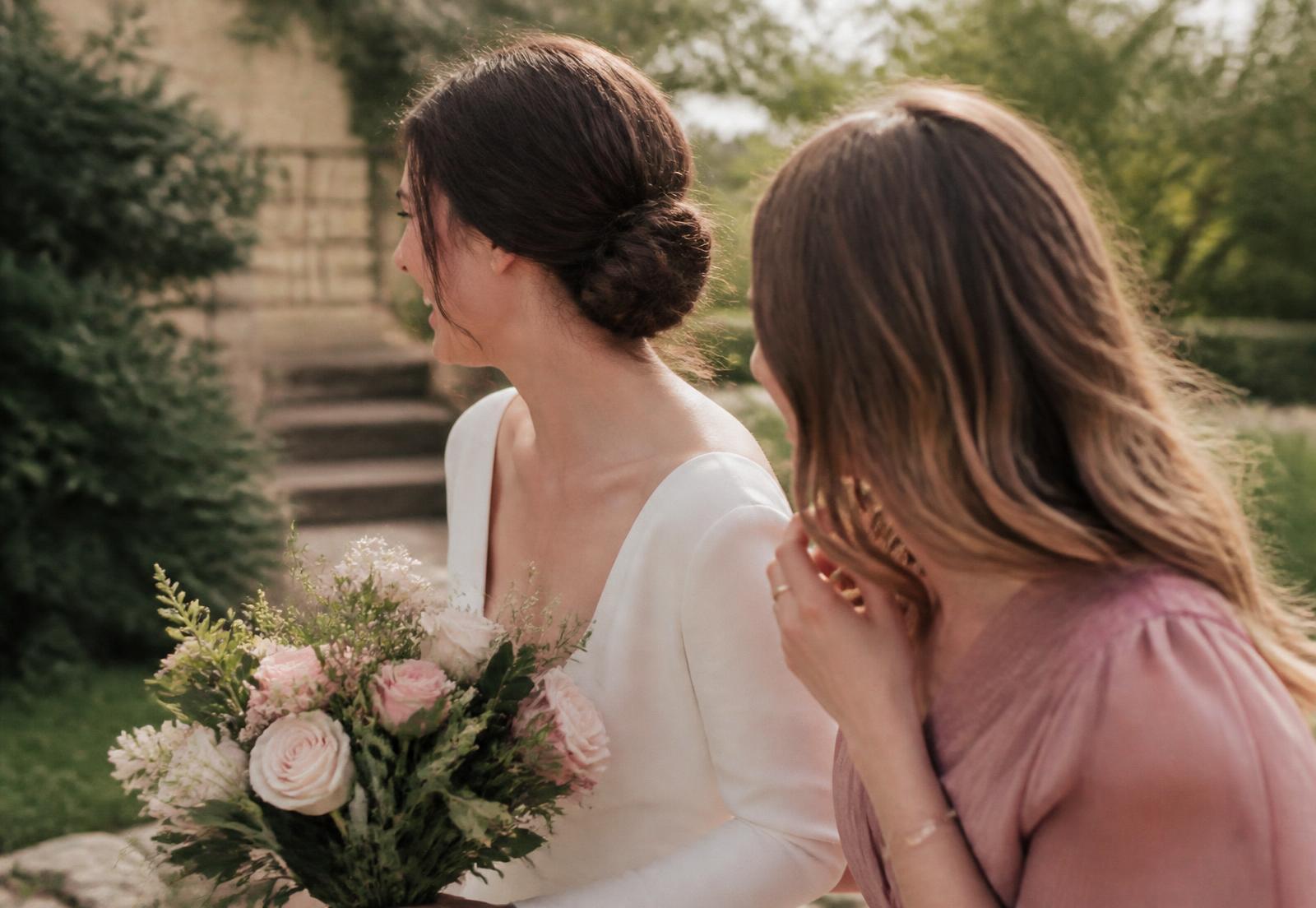Bride and wedding party member outdoors in soft daylight